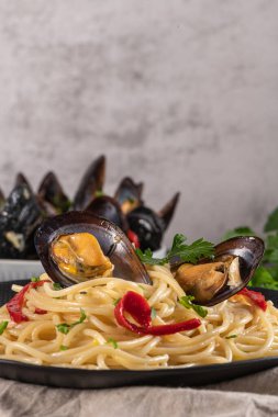 Kabuklu midyeli, biberli ve maydanozlu makarna. Deniz yemeği.