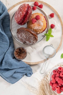 Bolas de Berlim, ya da Berlin Balls. Çikolata ya da ahududu reçeli ile doldurulmuş Portekiz usulü kızarmış hamur. Portekiz hamur tatlısı ve şeker.