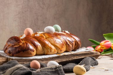 Portekiz geleneksel paskalya pastası. Paskalya masasında yumurtalı folar. Çiçekli laleler, renkli boyanmış yumurtalar ve tüyler.