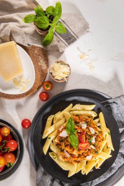 Lezzetli iştah açıcı klasik İtalyan makarna vejetaryen mercimek bolonez soslu, peynirli parmesan peyniri ve açık tabakta fesleğen. Sağlıklı yeme kavramı.