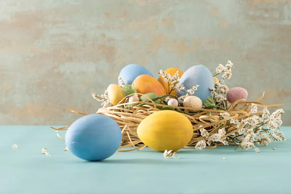 Ovos Azuis Amarelos Páscoa Pequeno Ninho Flores Fundo Azul — Fotografia de Stock