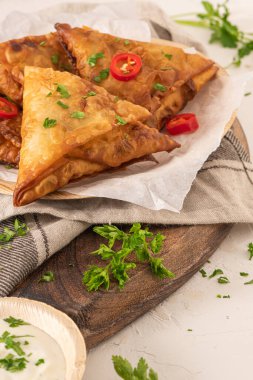 Hint samosaları - baharatlı ve baharatlı areca yaprağı tabaklarında yoğurt sosu ile servis edilen baharatlı baharatlı baharatlı baharatlı baharatlı baharatlı, baharatlı ve baharatlı hamur tatlısı.