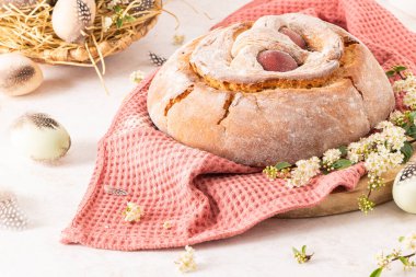 Yumurtalı geleneksel Portekiz Paskalya pastası. Tipik Folar de Vale de Ilhavo, Aveiro, Portekiz. Çiçekler ve renkli boyanmış yumurtalar Paskalya masasında tüylerle süslenmiş.