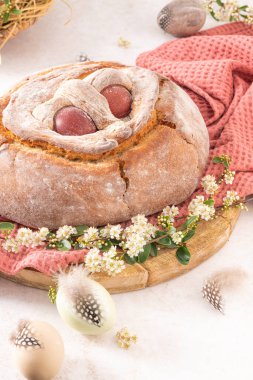 Yumurtalı geleneksel Portekiz Paskalya pastası. Tipik Folar de Vale de Ilhavo, Aveiro, Portekiz. Çiçekler ve renkli boyanmış yumurtalar Paskalya masasında tüylerle süslenmiş.