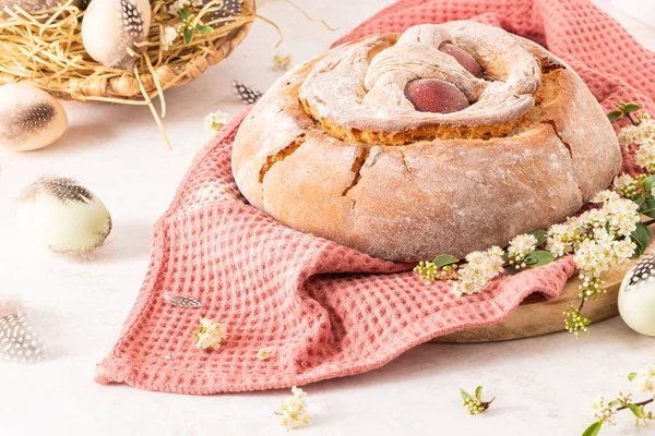 Yumurtalı geleneksel Portekiz Paskalya pastası. Tipik Folar de Vale de Ilhavo, Aveiro, Portekiz. Çiçekler ve renkli boyanmış yumurtalar Paskalya masasında tüylerle süslenmiş.