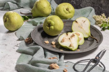 Fındık ile lezzetli armut. Çiçeklerle süslenmiş bir masa ve plakaya kesilmiş bir tabak armut