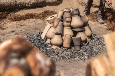 AMARANTE, PORTUGAL - CRCA APRIL 2022: 2022 Nisan 2022 'de Portekiz' in Amarante şehrinde Gondar 'ın kara kilinin ateşleme işlemi sırasında şenlik ateşinin közlerinin üzerine kil parçaları istiflemek.