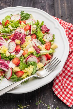 Tahta arka planda yeşil turp peyniri ve domatesli taze salata. İtalyan Akdeniz veya Yunan mutfağı.