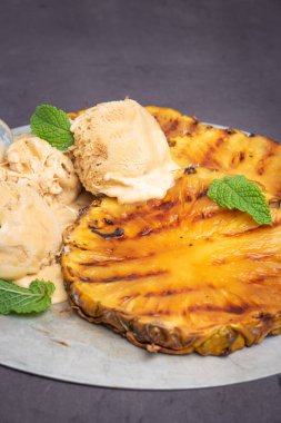 Vanilyalı dondurma ve nane yaprakları ile ızgara ananas