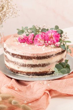 Taze güllerle çikolatalı, çıplak pasta ve beyaz arka planda İsviçre tereyağı.