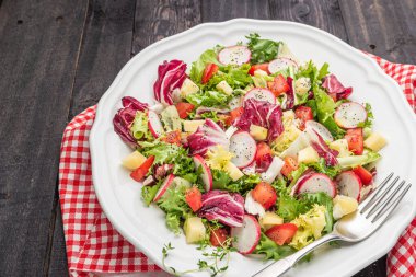 Tahta arka planda yeşil turp peyniri ve domatesli taze salata. İtalyan Akdeniz veya Yunan mutfağı. Vejetaryen yemeği..