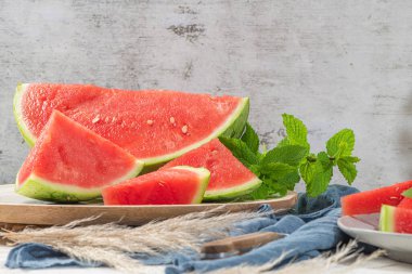 Olgun karpuz bileşimi ve mutfak masasında taze nane. Olgun yaz karpuzu. Sulu karpuz. Masadaki mevsimlik meyve kavramı