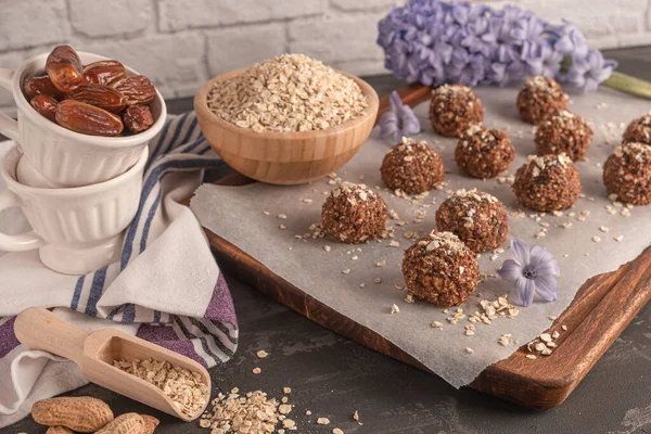 Healthy organic energy granola balls with oat flakes, peanuts, dates, cacao, banana, chocolate and honey - vegan vegetarian raw snack or meal