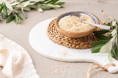 Raw white quinoa seeds (lat. Chenopodium quinoa) in ceramic bowl in kitchen countertop. Gluten free Healthy food. Diet, dieting concept. Superfood concepts. Healthy vegetarian food ingredient.