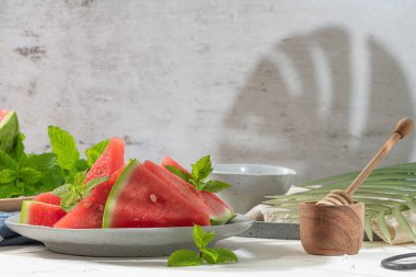 Olgun karpuz bileşimi ve mutfak masasında taze nane. Olgun yaz karpuzu. Sulu karpuz. Masadaki mevsimlik meyve kavramı