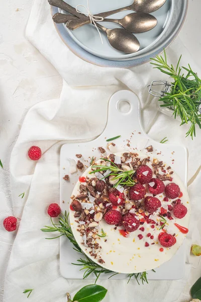 Mutfakta ahududu, çikolata, fındık ve biberiye yapraklı cheesecake.