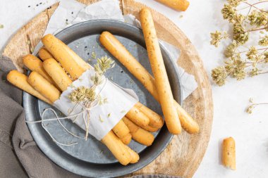 Breadsticks grissini. Bread sticks with sesame seeds, oregano and olive oil and balsamic vinegar on kitchen countertop. Top view. Flat lay with copy space