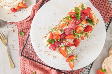 Yumuşak bir kremalı kremalı krema, çıtır fıstık, nane, biberiye ve ahududu ve çilekle dolu. Pavlova Yazı tatlı tatlı tatlı.