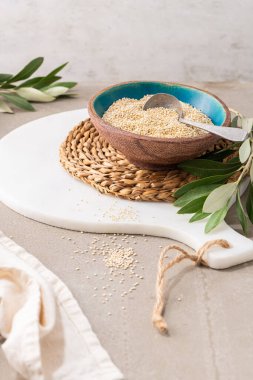 Çiğ beyaz kinoa tohumları (lat. Chenopodium kinoa) mutfak tezgahındaki seramik kasede. Glütensiz sağlıklı yemek. Diyet, diyet konsepti. Glütensiz diyet ve süper yiyecek kavramları için kuru chenopodium kinoa. Sağlıklı vejetaryen besin maddeleri.