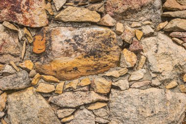 Duvarlar çok renkli taşlardan yapılmış, Stone arkaplan. Antik taş duvar. Grunge Stone duvar arkaplanı. Eski bir taş duvarın arka planı. Duvar süslemesi doğal taşla güzel ve güçlü olmalı..