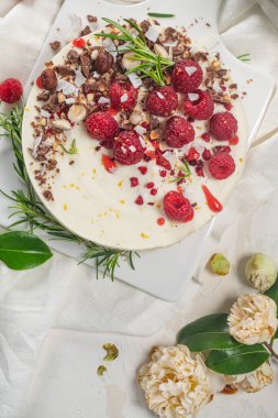 Mutfakta ahududu, çikolata, fındık ve biberiye yapraklı cheesecake.