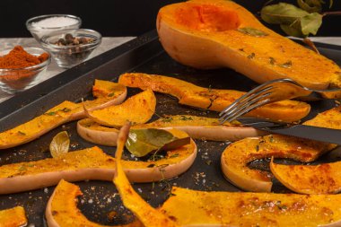 Fırınlanmış kabak dilimleri, baharatlar ve koyu yaprak. Seçici odak.