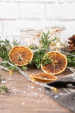 Noel için arka planda yanan mumlar ve kırsal ahşap tahtada doğal süslemeler. Metnin için çam dalları ve boşluk olan arkaplan.