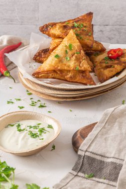 Hint samosaları - baharatlı ve baharatlı areca yaprağı tabaklarında yoğurt sosu ile servis edilen baharatlı baharatlı baharatlı baharatlı baharatlı baharatlı, baharatlı ve baharatlı hamur tatlısı.