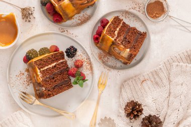 Karamel soslu, böğürtlen ve ahududu ile süslenmiş lezzetli yarı çıplak çikolatalı pasta. Hafif arkaplan