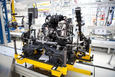 fabrika üretim hattında ayakta araba motoru monte