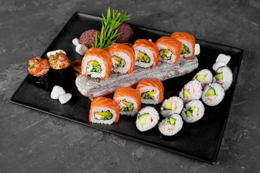 Kare siyah tabakta suşi. Eski ahşap arkaplan.