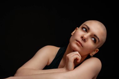 Güzel, gülümseyen kel bir kadının portresi. Stüdyo çekimi koyu arkaplanda