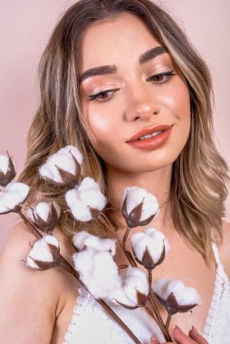 Genç güzel kız elinde pamuk bir dal tutuyor..