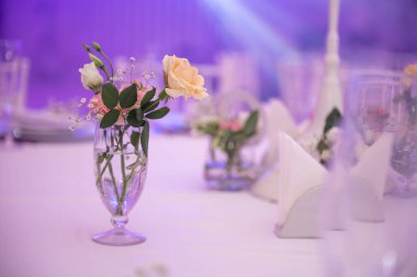 Açık arkaplanda çiçek dekoru olan güzel masa ayarları, yakın plan.