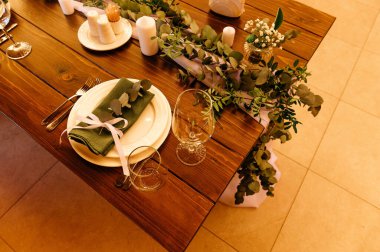 Masa örtüsü olmayan ahşap bir masa taze çiçeklerle servis edilir ve dekore edilir. Açık Cafe.