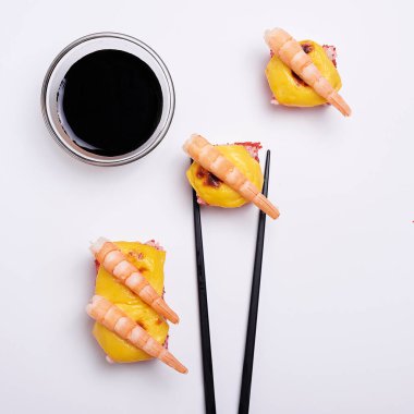 dört parça karides soya soslu beyaz arka planda.