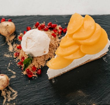 Üzüm ve nar ile süslenmiş dondurmalı leziz cheesecake tatlısı.