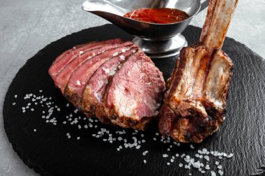 Soslu domuz kemiği, siyah tepside servis edilen restoran, üst manzara.