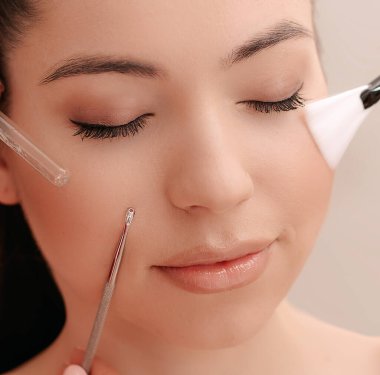 Yüzünde fırça ve ruj izi olan makyaj sanatçılarının elleri ile çevrili güzel bir kız. Kendini tımar ediyor.