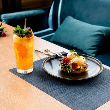 Lokantadaki masada limonata ve siyah tabakta hamburger..