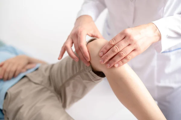 Γιατρός Εξετάζει Γόνατό Της Στο Ιατρείο Πόνος Στα Πόδια Εικόνα Αρχείου