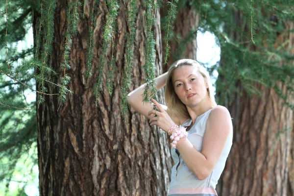 Mladá žena poblíž stromů — Stock fotografie