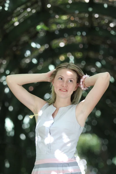 Unga blonda kvinnan i park — Stockfoto