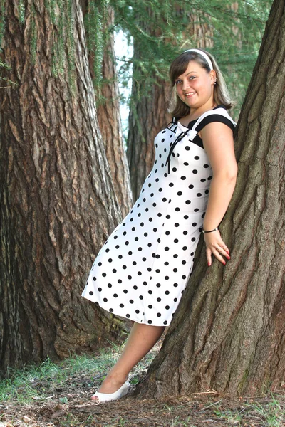 Happy young woman in white dress in park — Stock Photo, Image