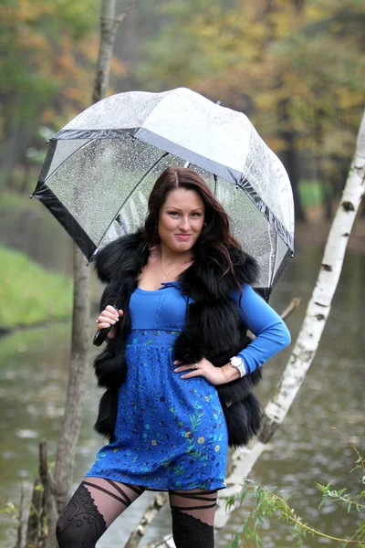 Mooie vrouw met paraplu in herfst park — Stockfoto