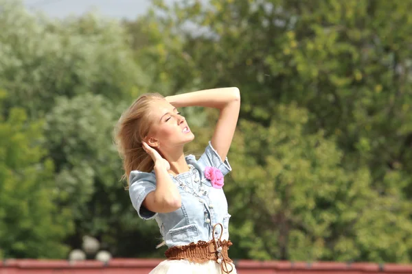 Pretty blonde woman walking in park — Stock Photo, Image