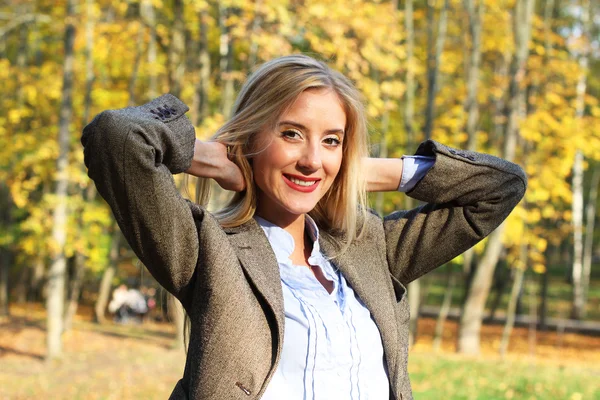 Happy blonde woman in autumn park — Stock Photo, Image