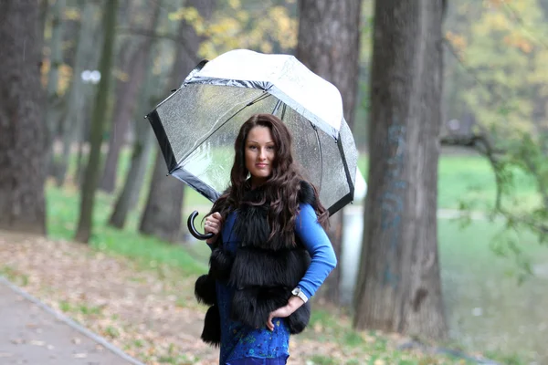 Mulher morena com guarda-chuva andando no parque — Fotografia de Stock