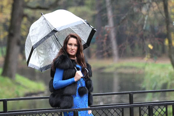 Brunette woman with umbrella in park — Stock Photo, Image