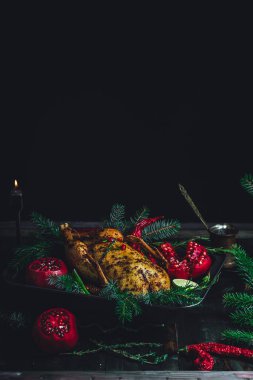 Christmas duck with pomegranates and lime surrounded by spruce branch